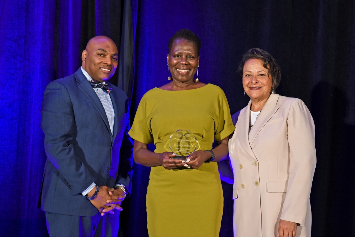 Carol Henderson standing with NADOHE award