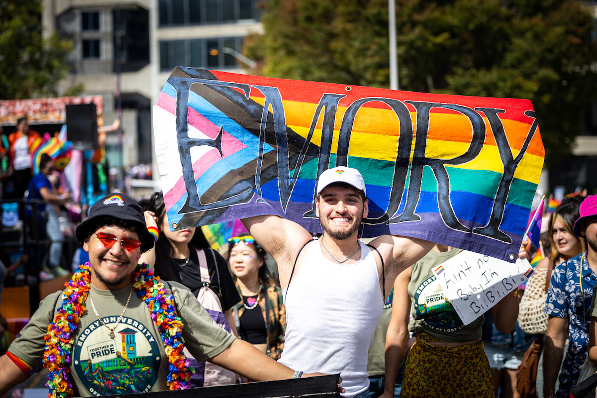 Photo: person holding Emory pride flag during parade