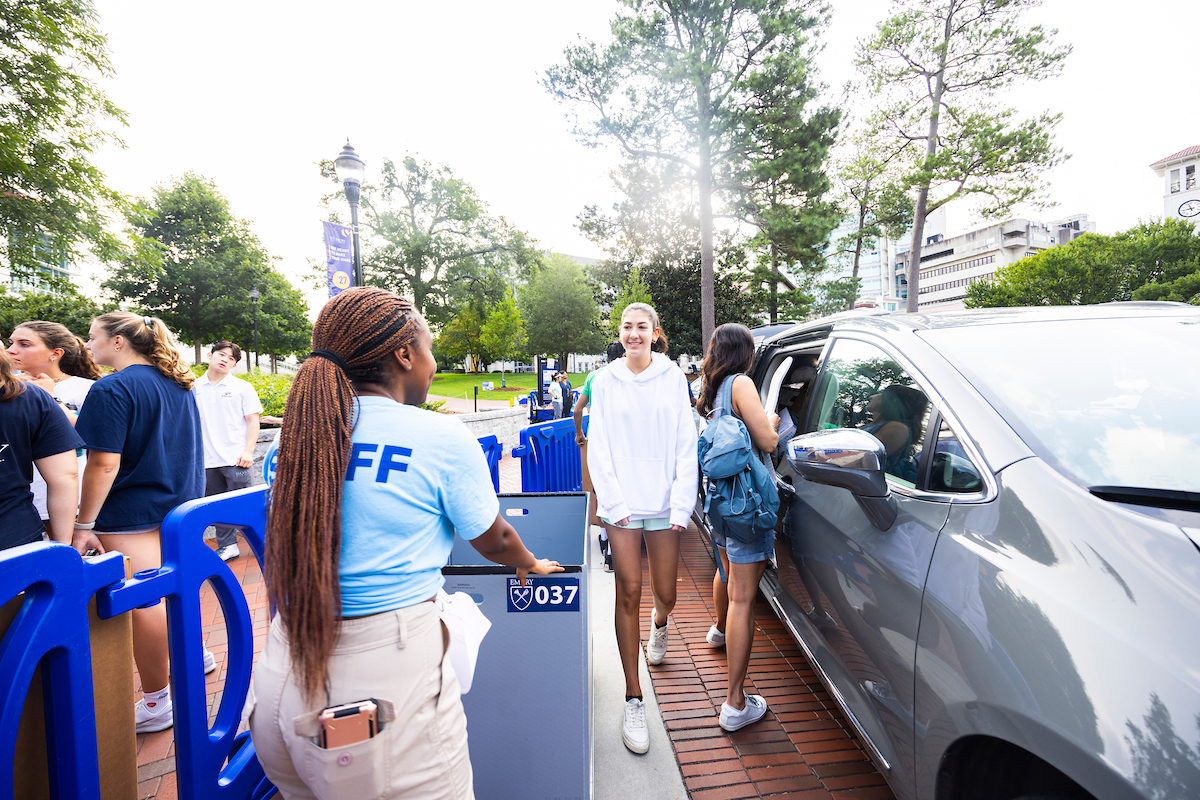 Photo: Students arriving on campus by car a being greeted by Emory staff