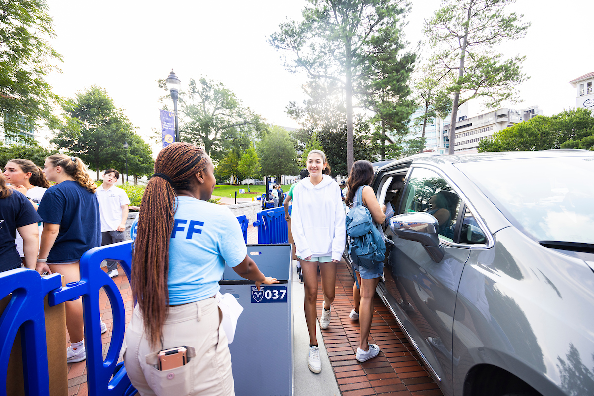 person with Staff t-shirt helping a new student move in