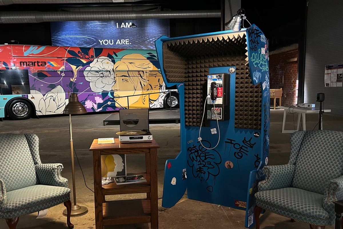 Photo: Space-age phone booth, two padded chairs, table, and laptop 