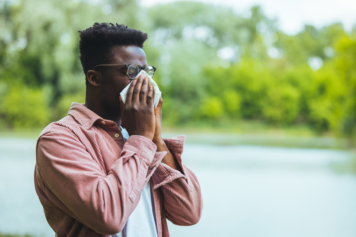 Photo: Man sneezing into hankerchief