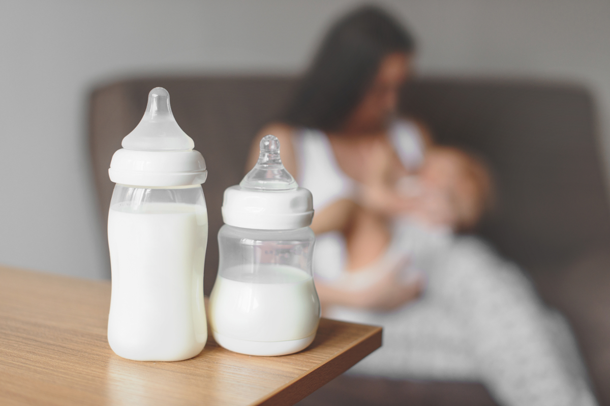 Breast milk bottle and mother with baby
