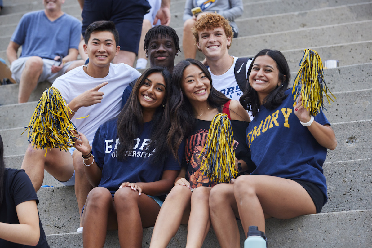 Photo of six Emory students in school colors, smiling for the camera
