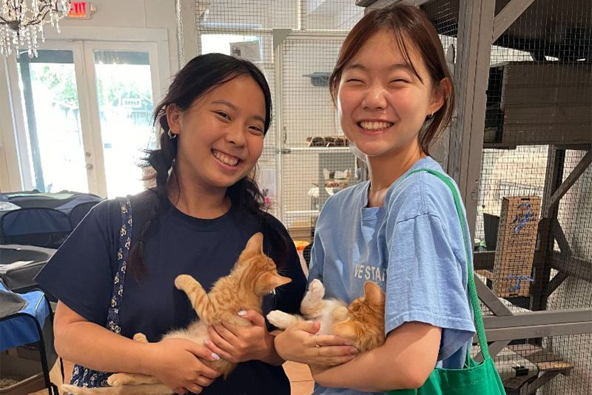 Photo: Two students holding kittens at service event