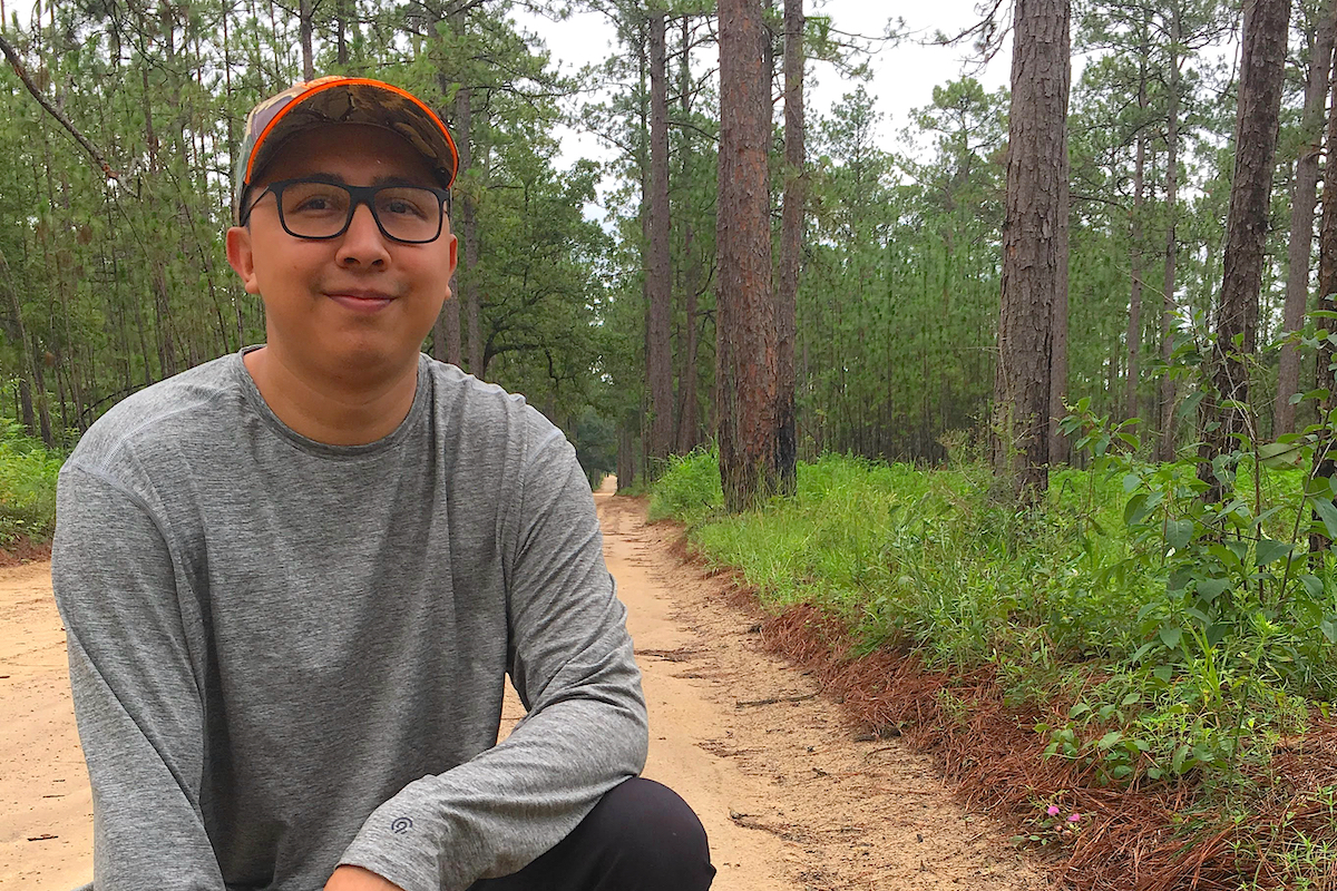 Photo of Marquez in wooded area, smiling into camera.