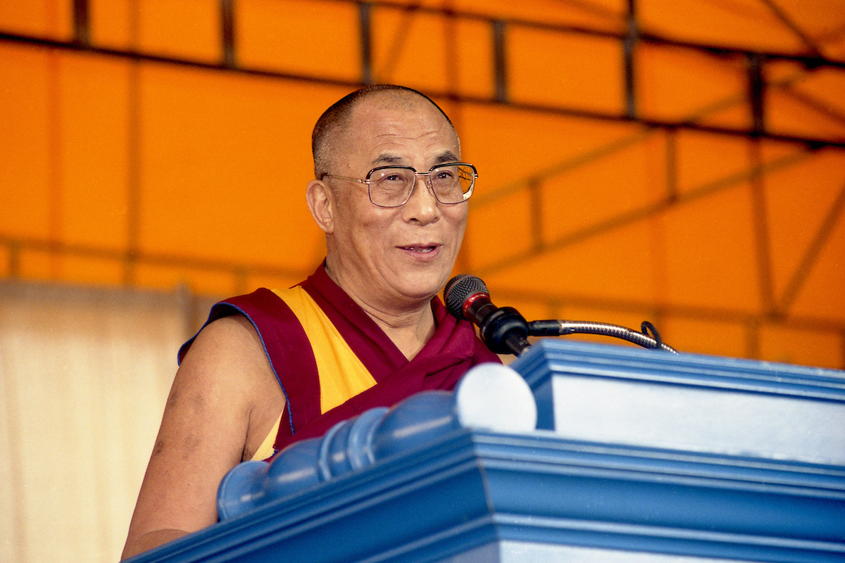 Photo of the Dalai Lama at a lecturn.