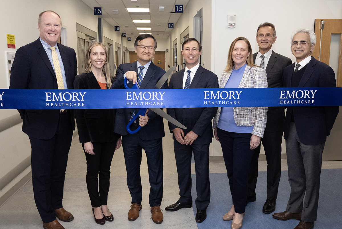 a group of emory healthcare leaders prepare to cut the ribbon of the new hospital facility.