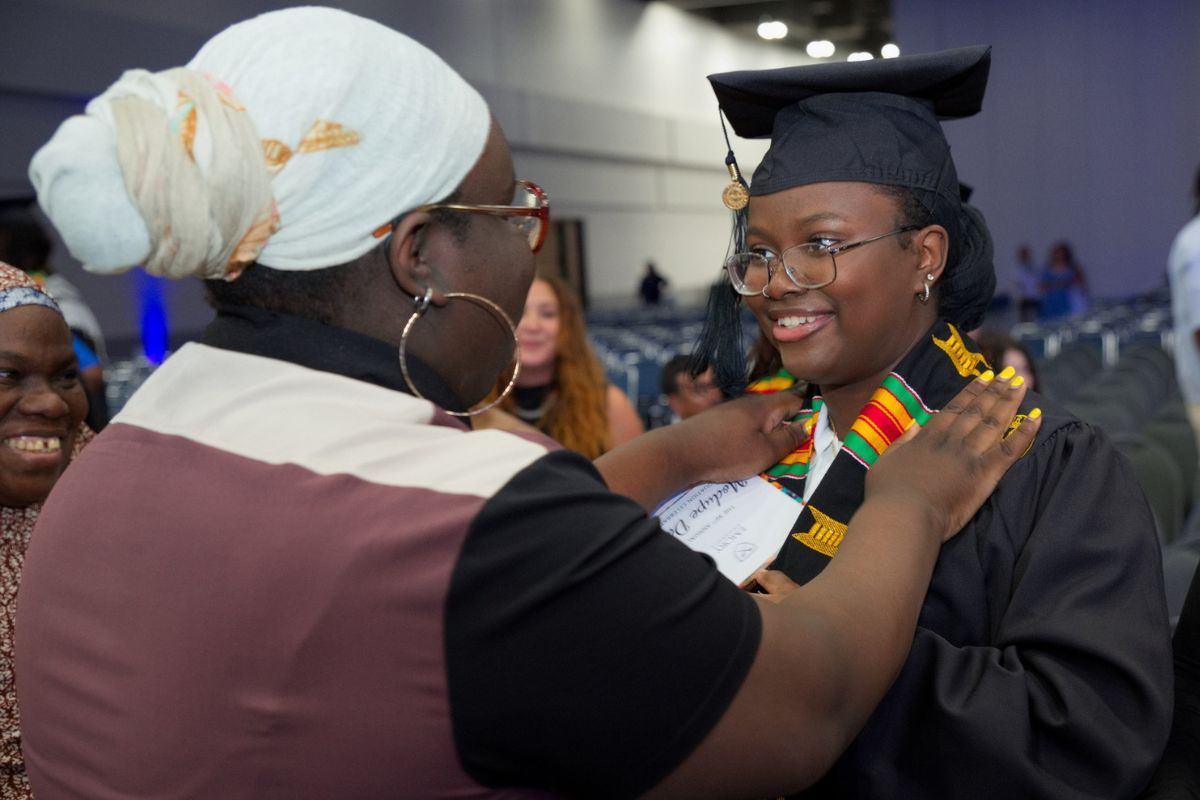 a person placing a stole over a graduate 
