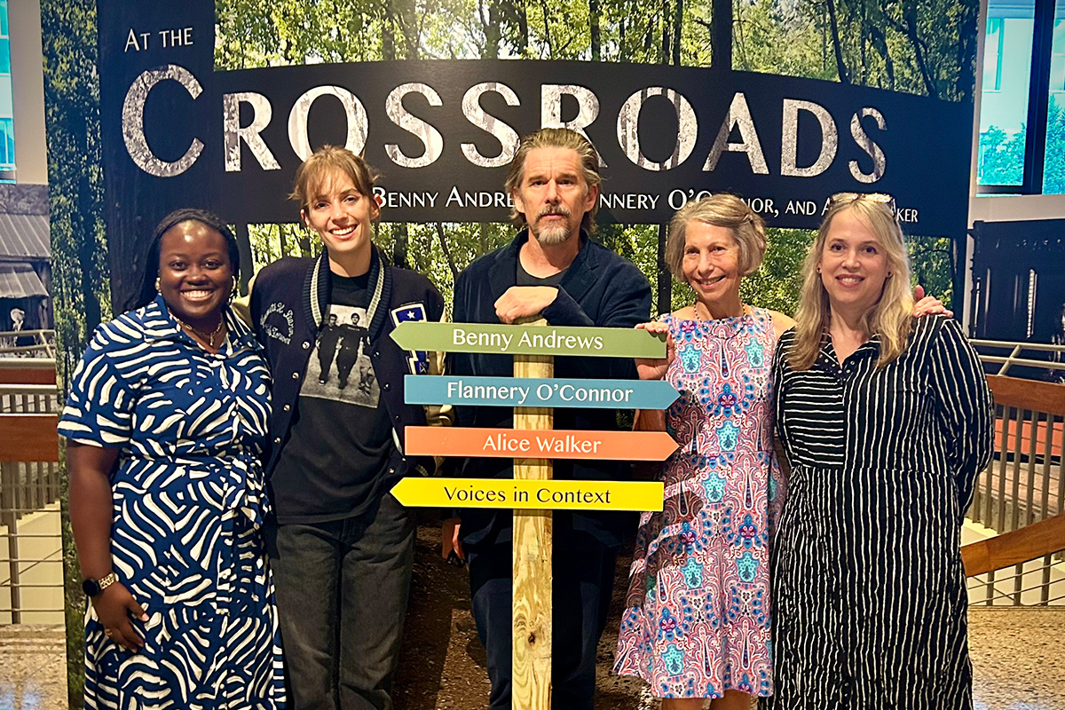crop of group at Crossroads sign