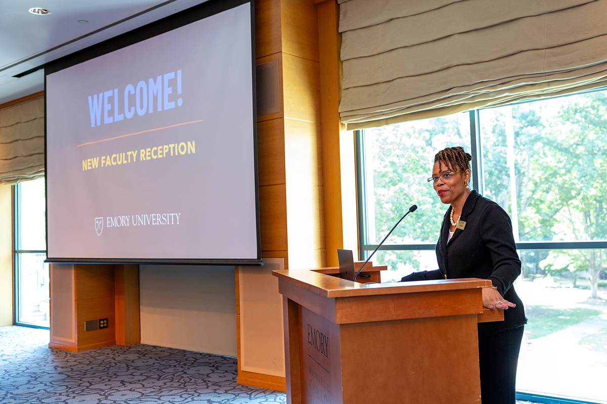 Pearl Dowe, vice provost for faculty affairs, speaks to new faculty from behind podium