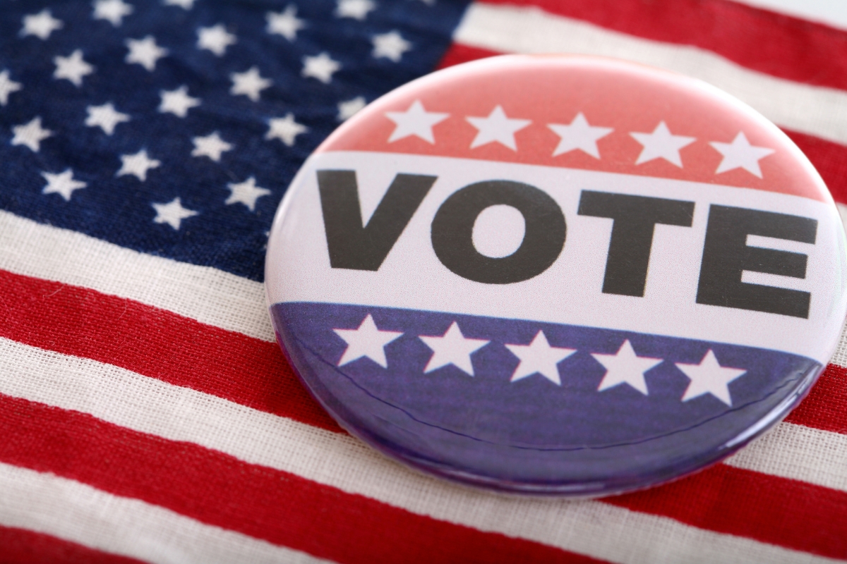 collection of red white and blue buttons that say vote