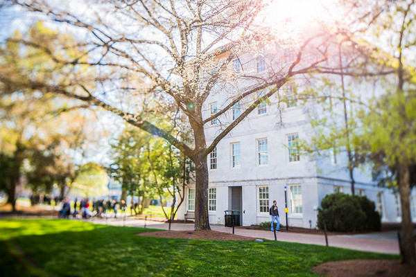 exterior photo of the Administration Building with students walking on a sunny day