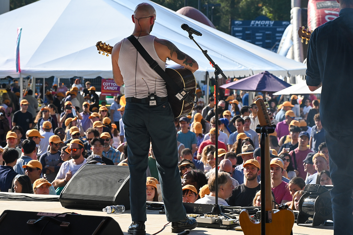 Performer on stage faces a large crowd