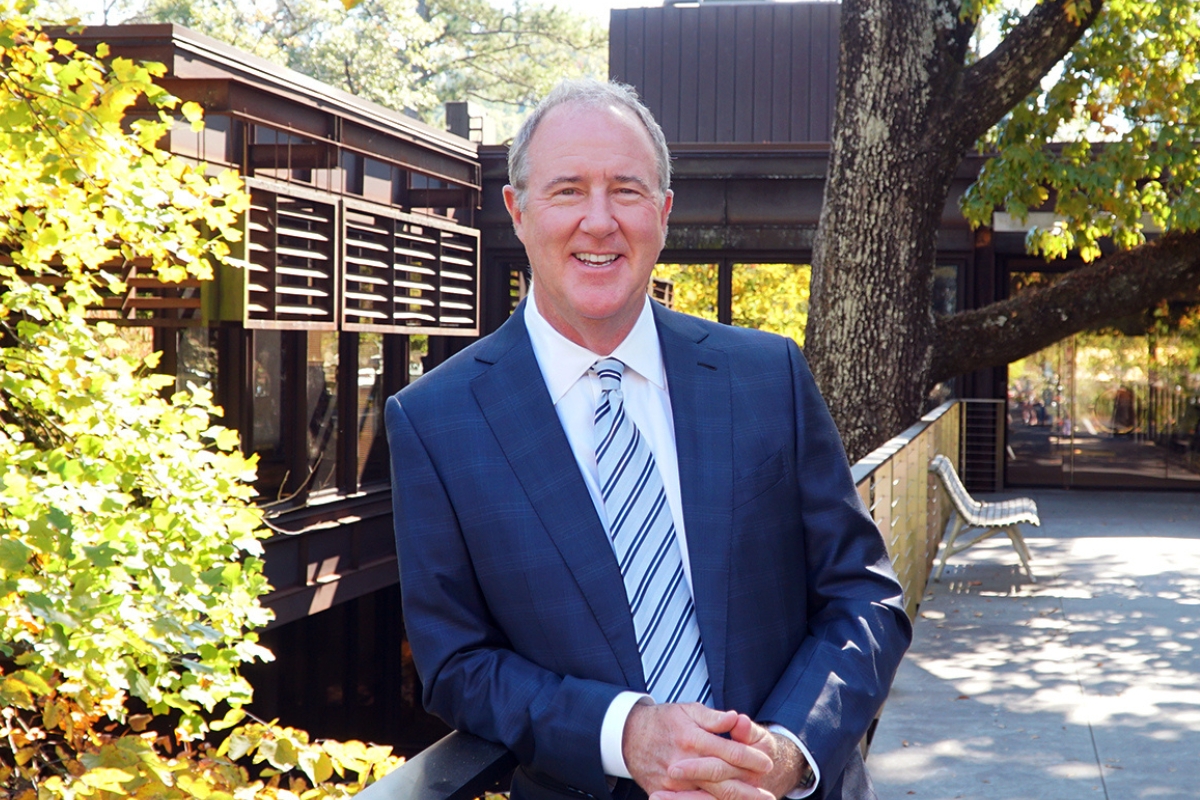 New Emory University trustee Billy Harbert standing outside with trees in the background