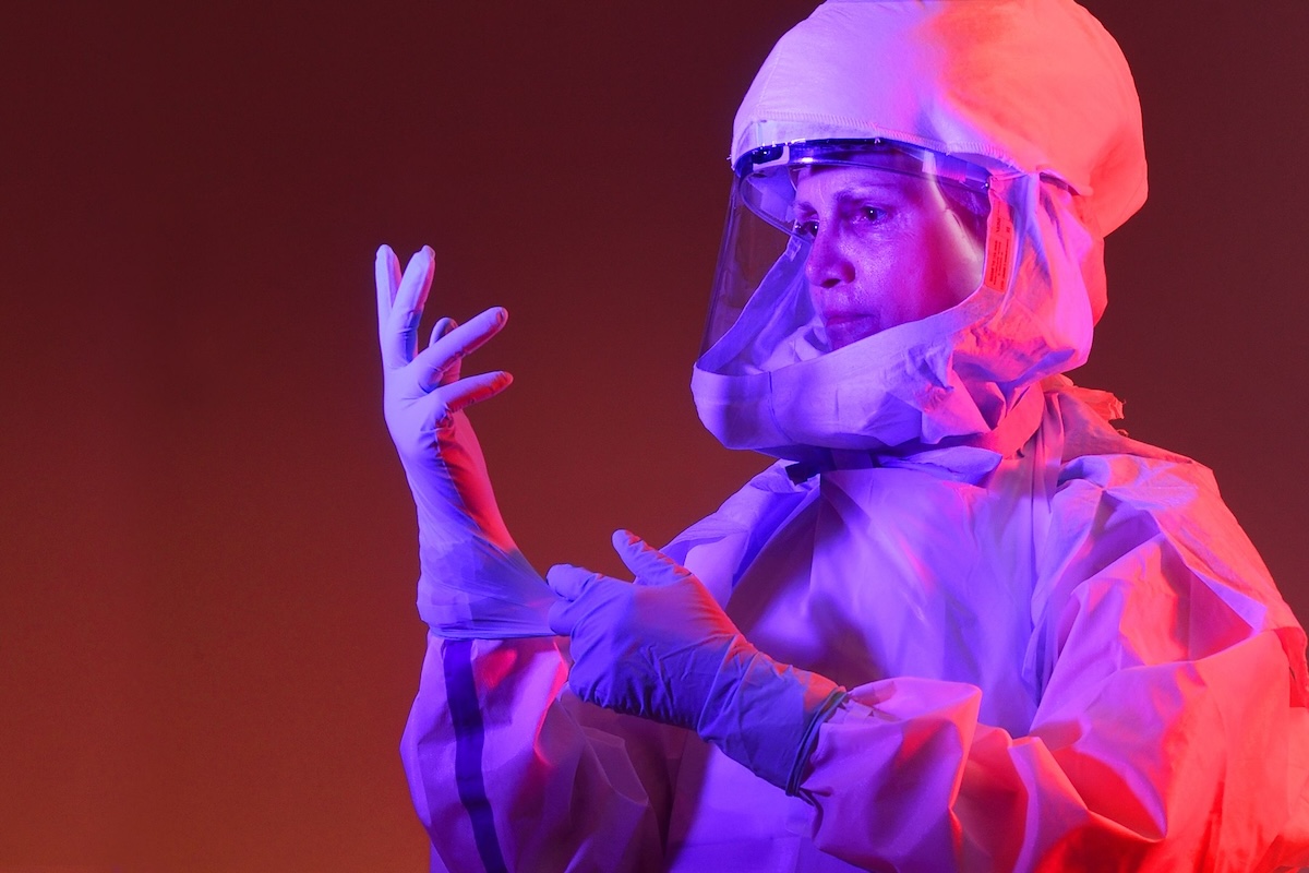 Woman in medical suit on pink background