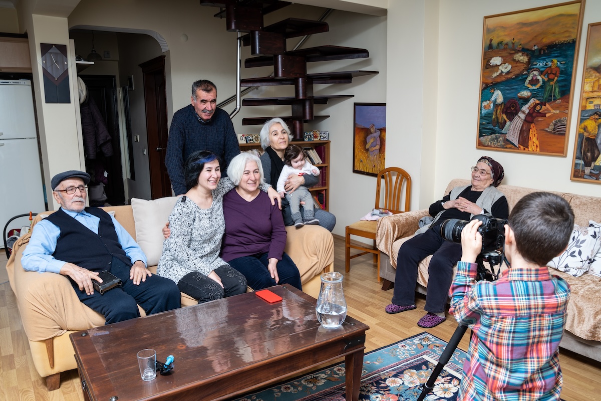 older adult in living room with extended family