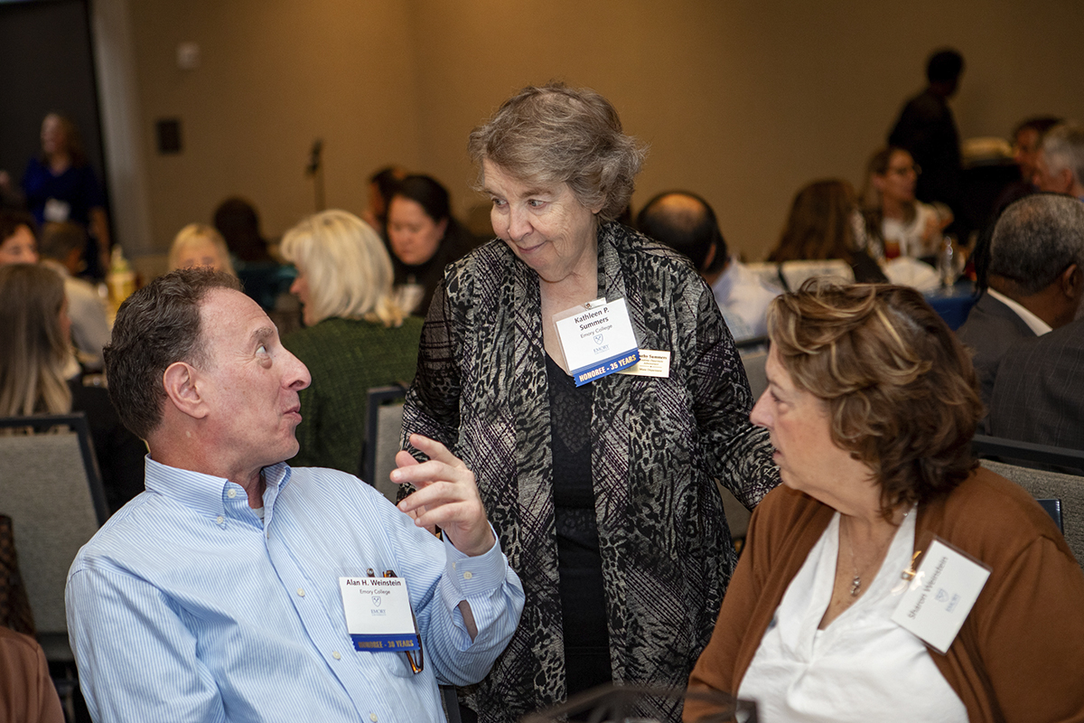 three adults talking at table