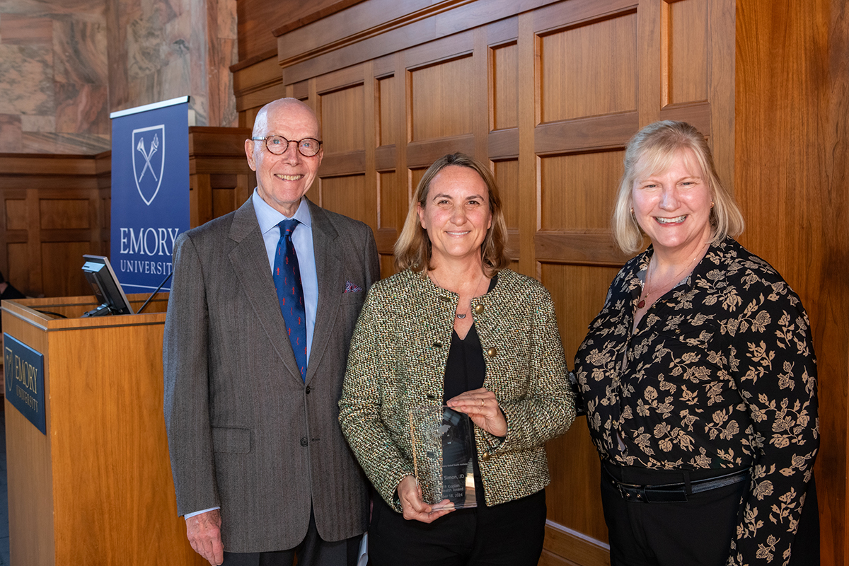 Awardee standing with presenters