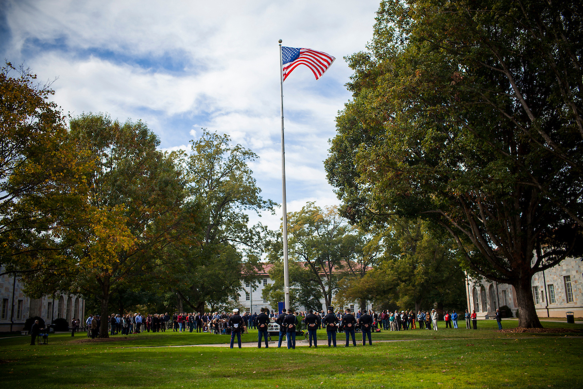 Veterans in uniform gathered around flag pole on Emory Quad