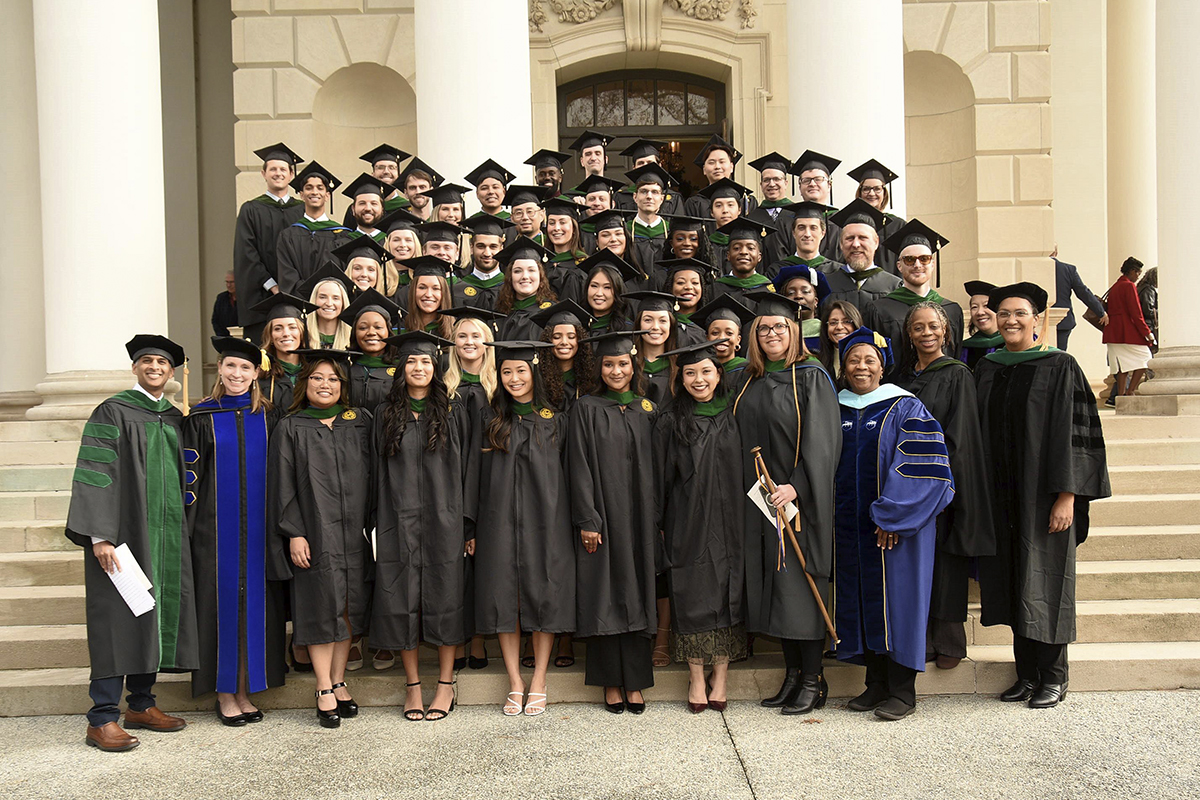 graduating students standing on steps outside a building