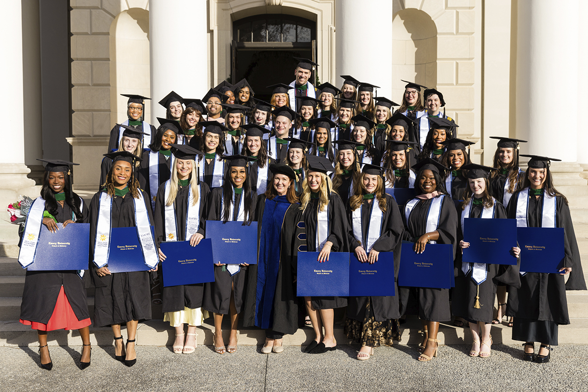 graduating students standing on steps outside a building