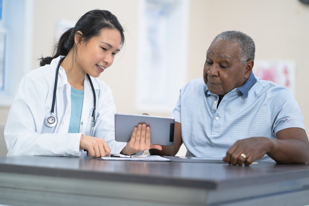 Nurse going over digital records with patient