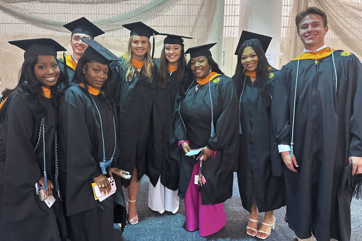 Graduates smiling at camera before graduation