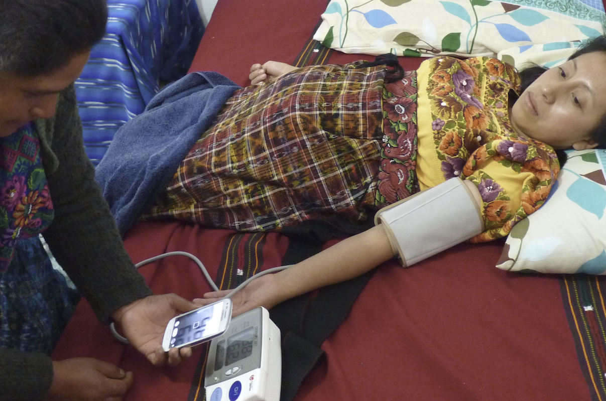 Indigenous midwife in Guatemala with hand held fetal heart monitor