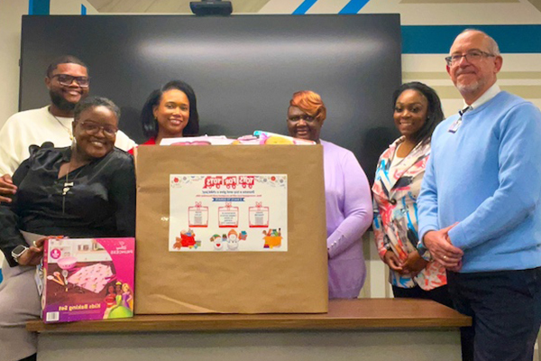 group of adults with a large box labeled for Toys for Tots collection