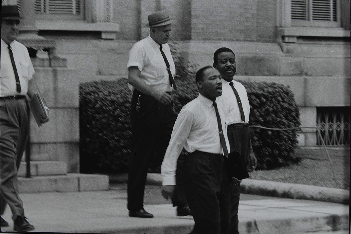 Martin Luther King Jr and Ralph David Abernathy walk down steps outside a courthouse