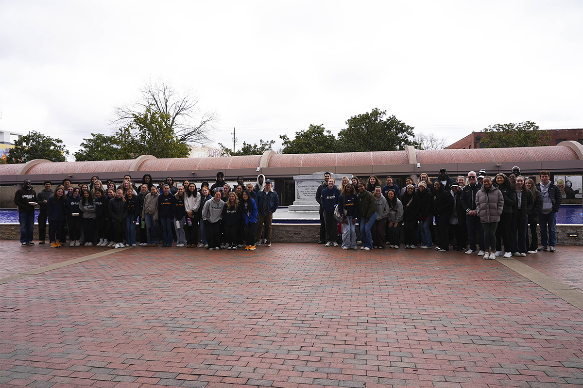 two large groups of people wearing winter coats standing on a brick plaza