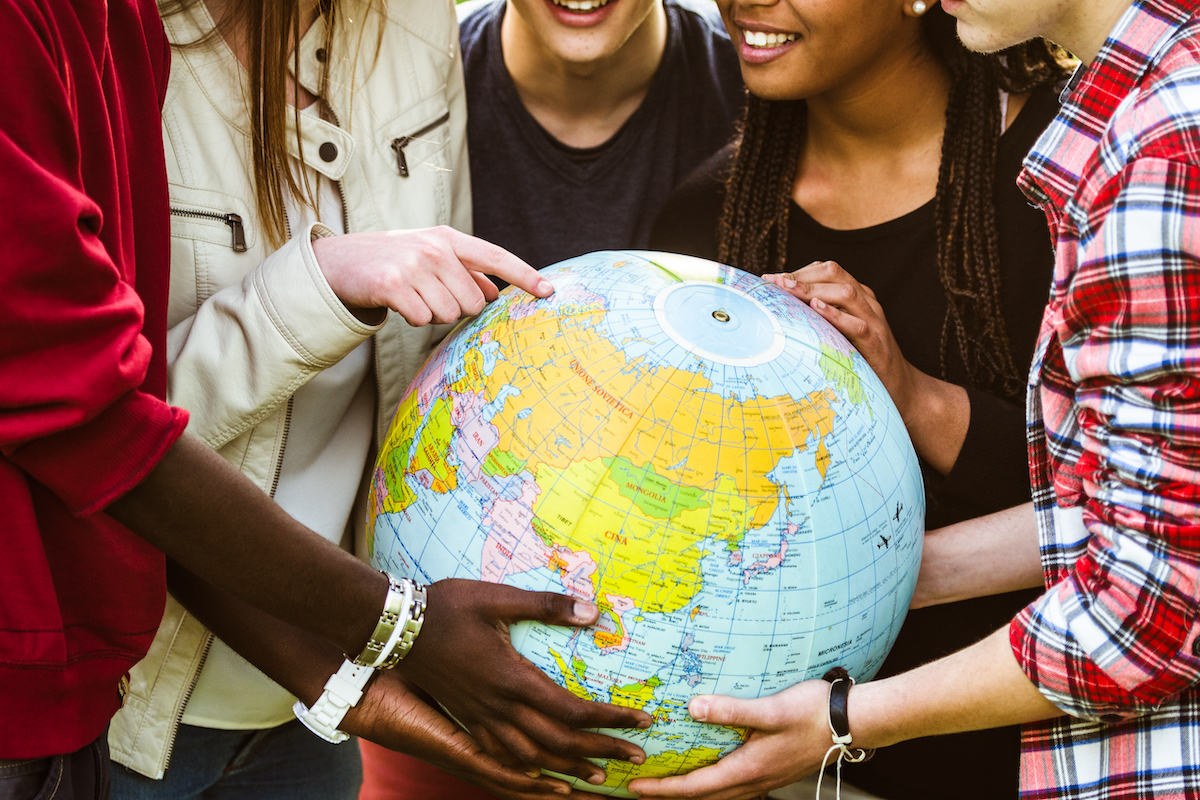 photo of people holding a globe 