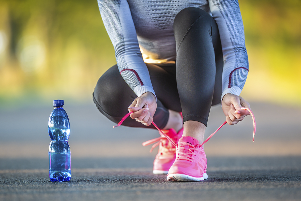 close up view of water bottle and hand weights on a gym floor