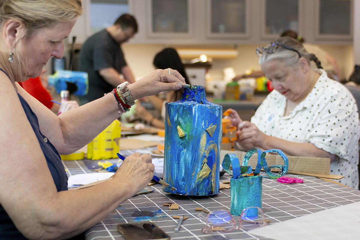 person painting a vase 