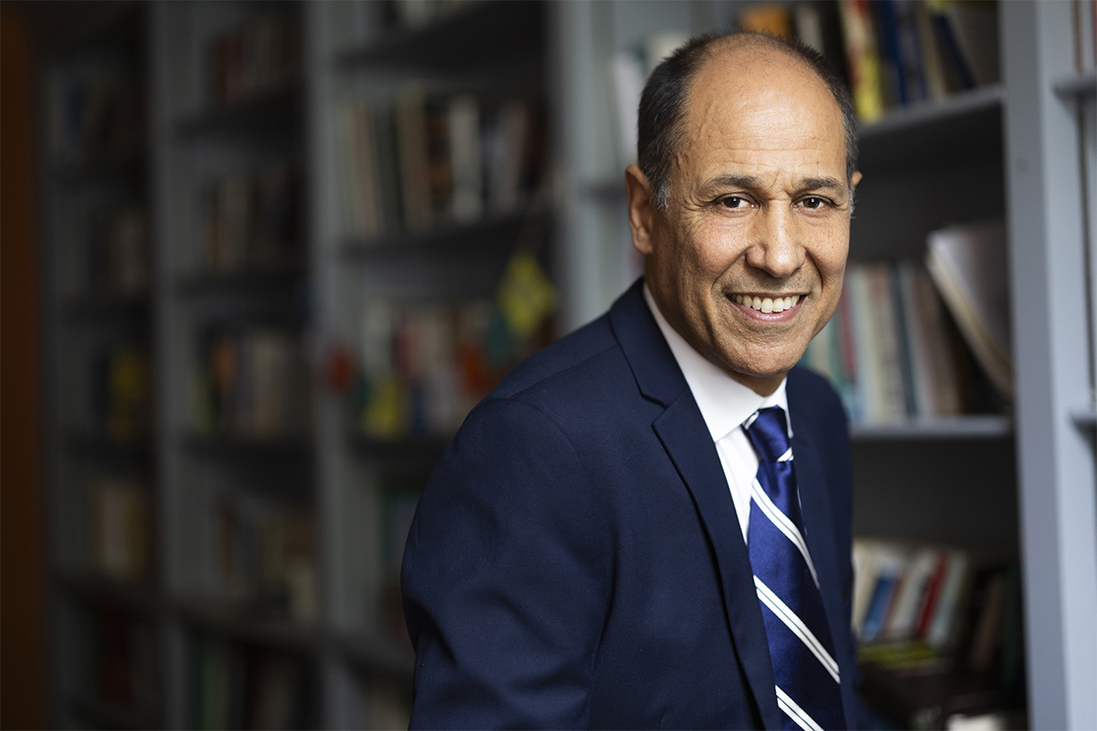 Emory University professor Sam Cherribi in his office in front of a wall full of bookcases