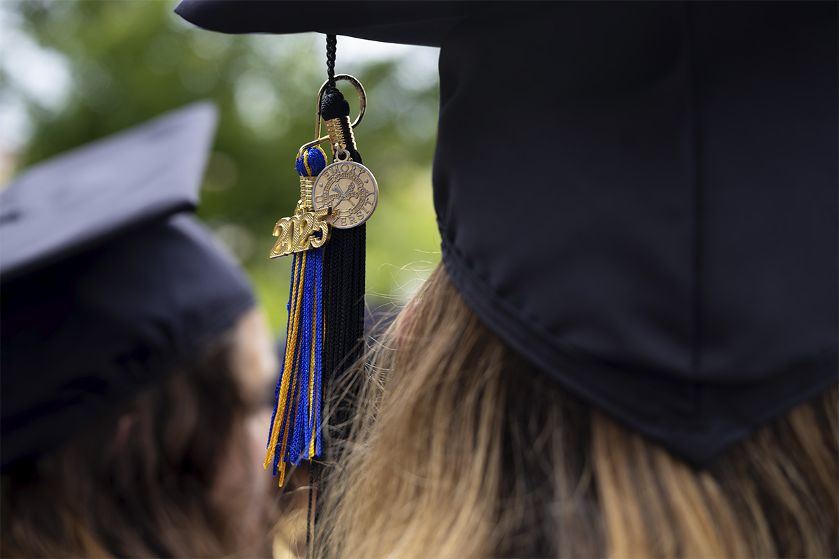 silhouettes of three adults in graduation caps and gowns