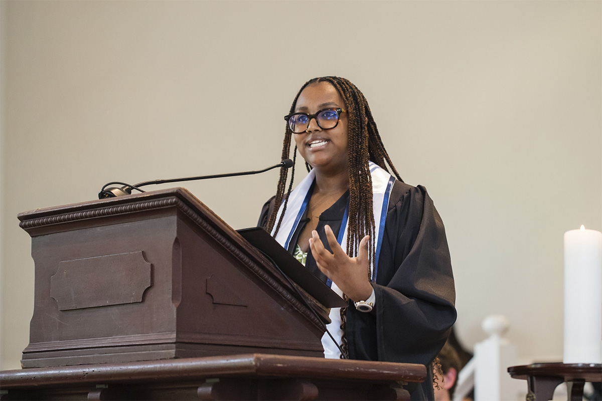 female college graduate speaking at podium