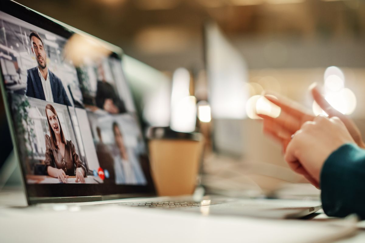person typing on keyboard in virtual meeting