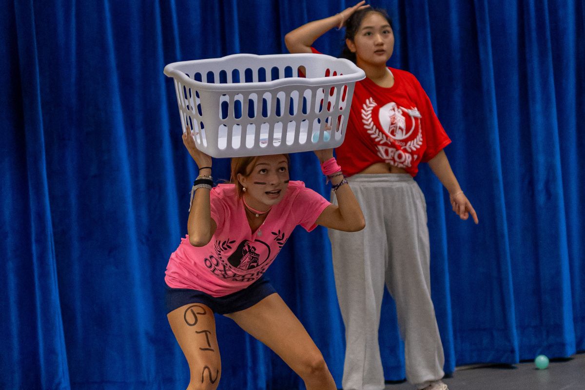 student with a basket over their head playing a game in the Oxford Olympics 