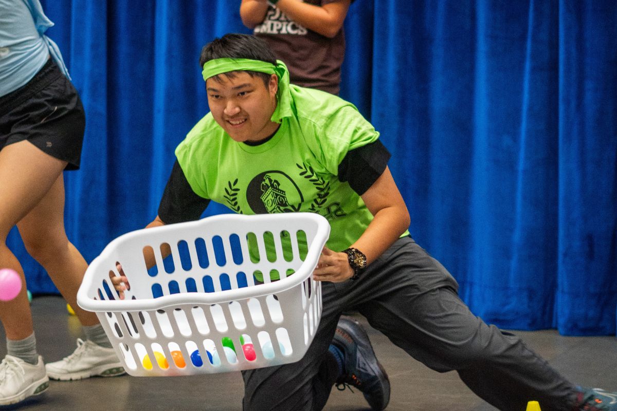 male student in green t-shirt playing a game in the Oxford Olympics