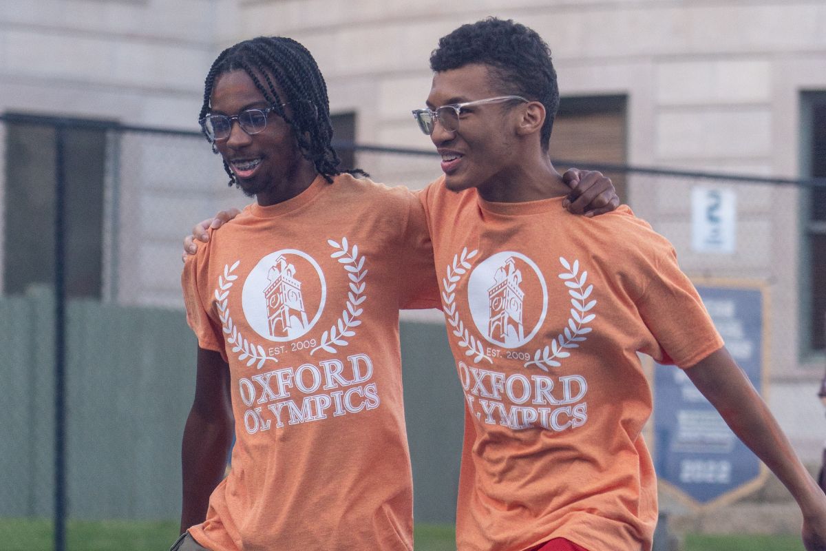 male students in orange t-shirts playing a game in the Oxford Olympics