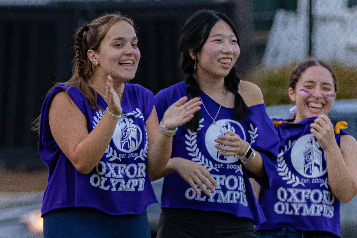 students in purple t-shirts cheering on team members at the Oxford Olympics 
