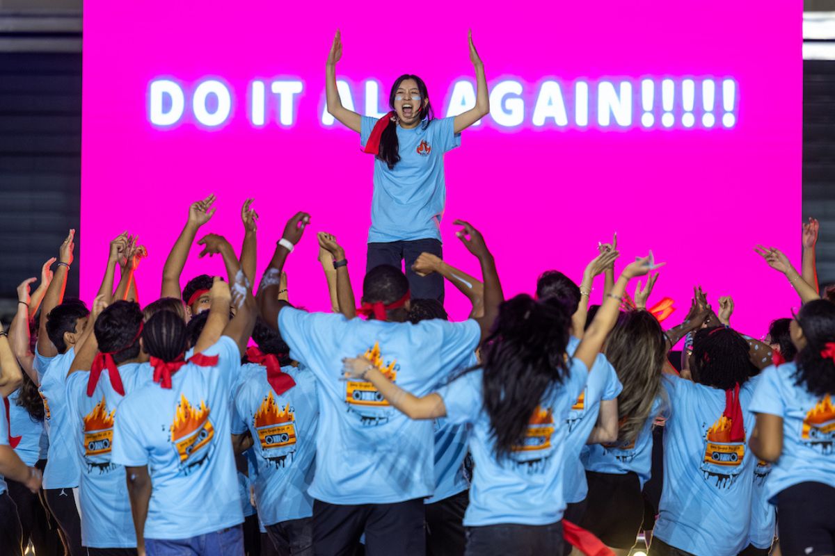 students in light blue t-shirts dancing during Songfest 