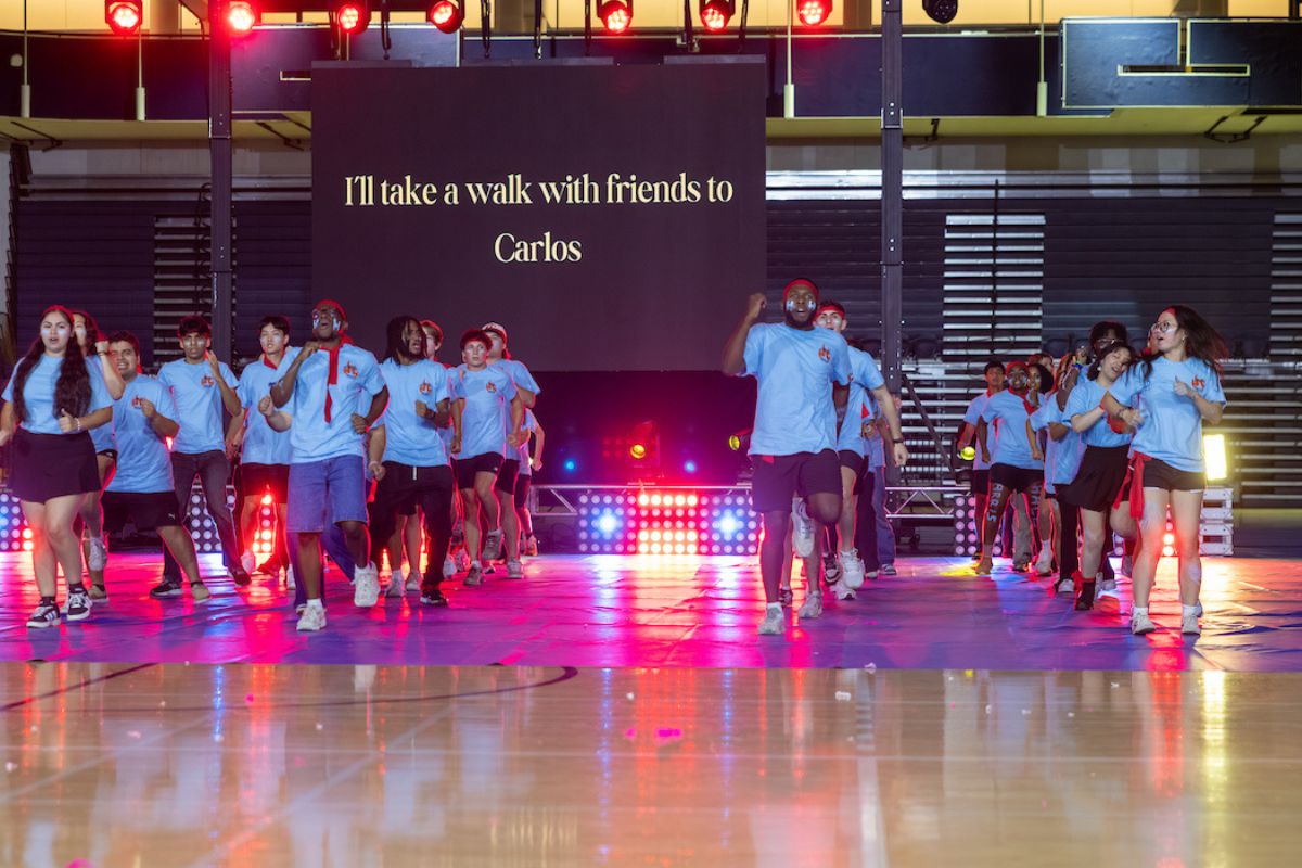students in light blue t-shirts dancing during Songfest 