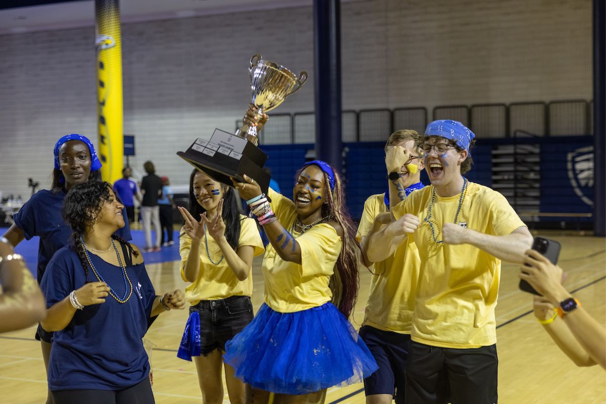 students holding the Songfest trophy 