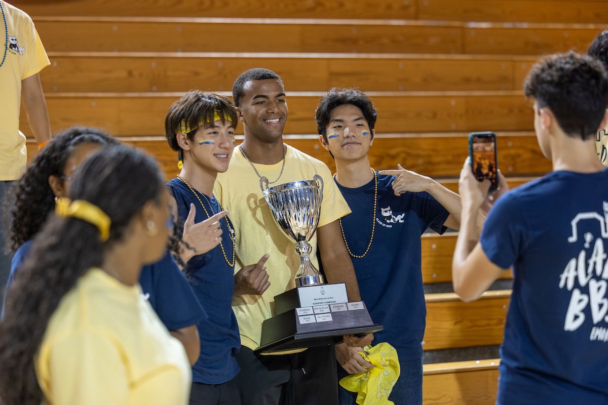 students holding the Songfest trophy 