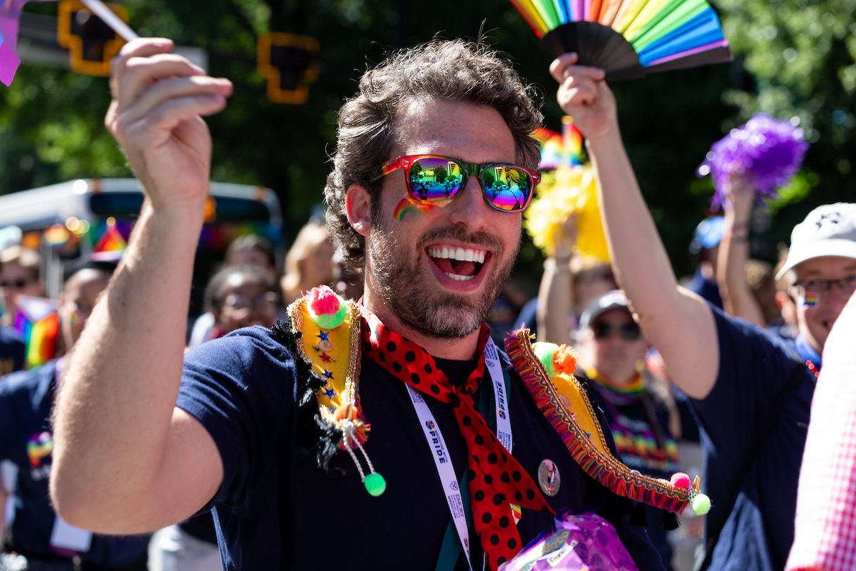 Man with rainbow apparel cheering