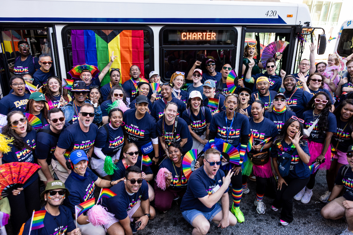 Large group of Emory Healthcare employees in front of shuttle bus