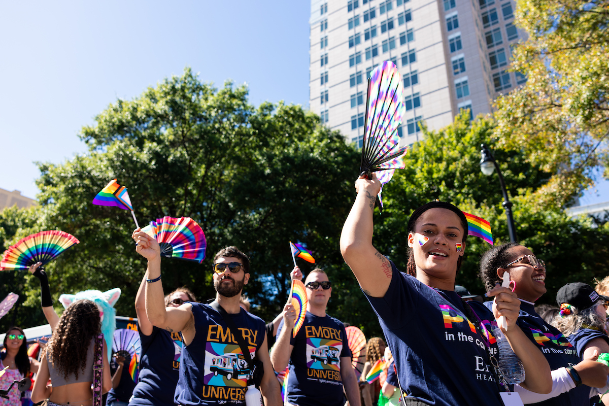 Parade goers with colorful fans waving